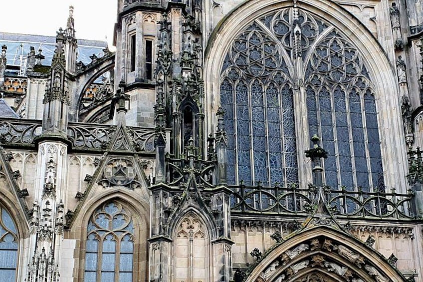 Une cathédrale de style gothique, caractérisée par ses sculptures en pierre complexes, ses grandes fenêtres à vitraux et son portail en arc surbaissé. 1
