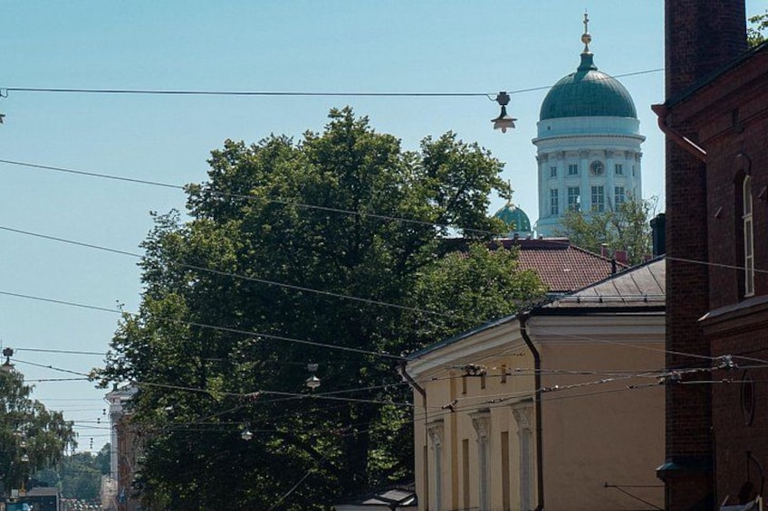 A large tree, a building with a dome, and a clear sky. 2