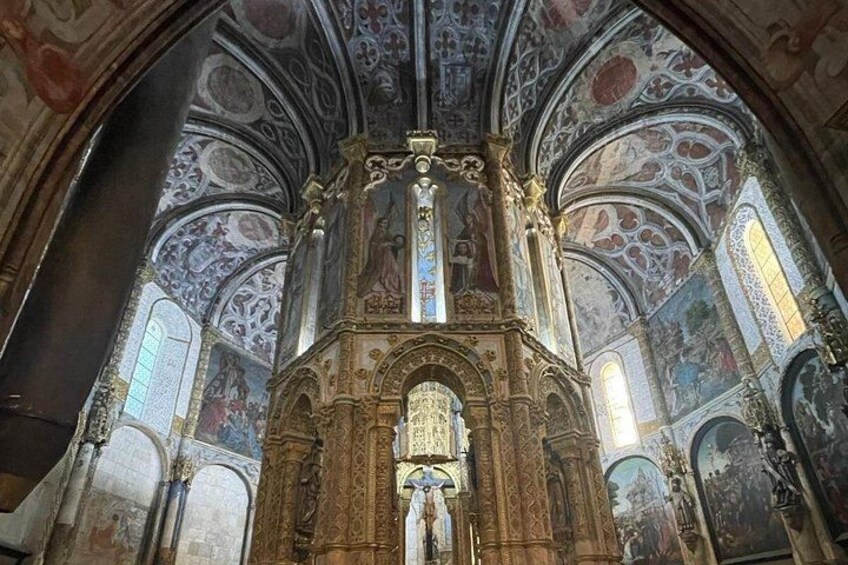 Interior de una iglesia ornamentada con frescos detallados y un altar central imponente. 5