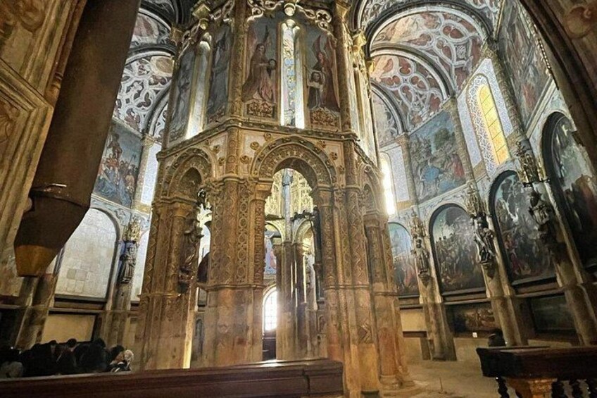 Interior de una iglesia ornamentada con altos techos abovedados, detallados relieves de piedra y frescos. 5