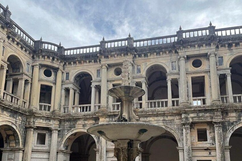 Un edificio histórico con una fuente central, ventanas en arco y un balcón. 4