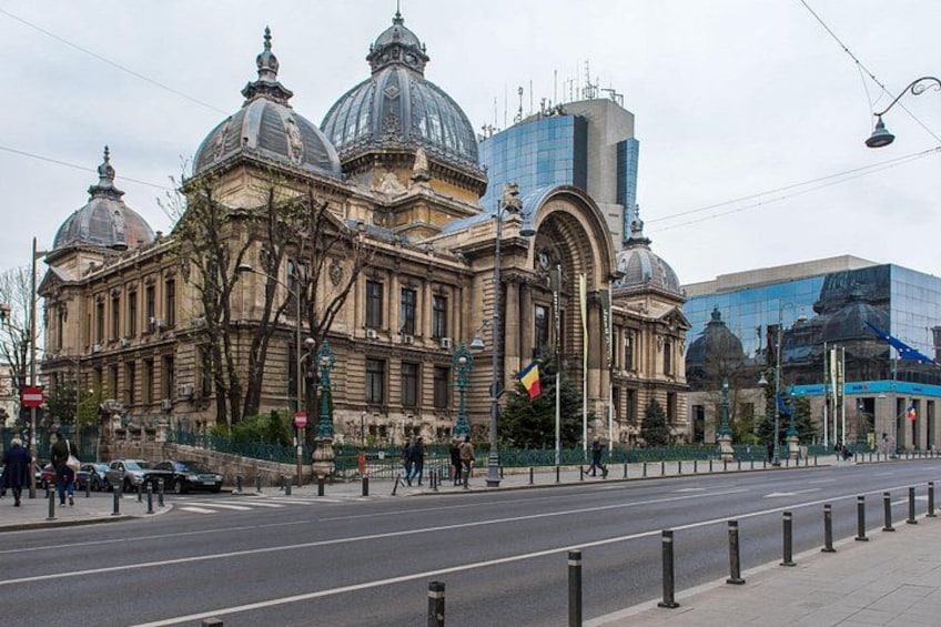 A historic building with domes and a modern glass structure. 2