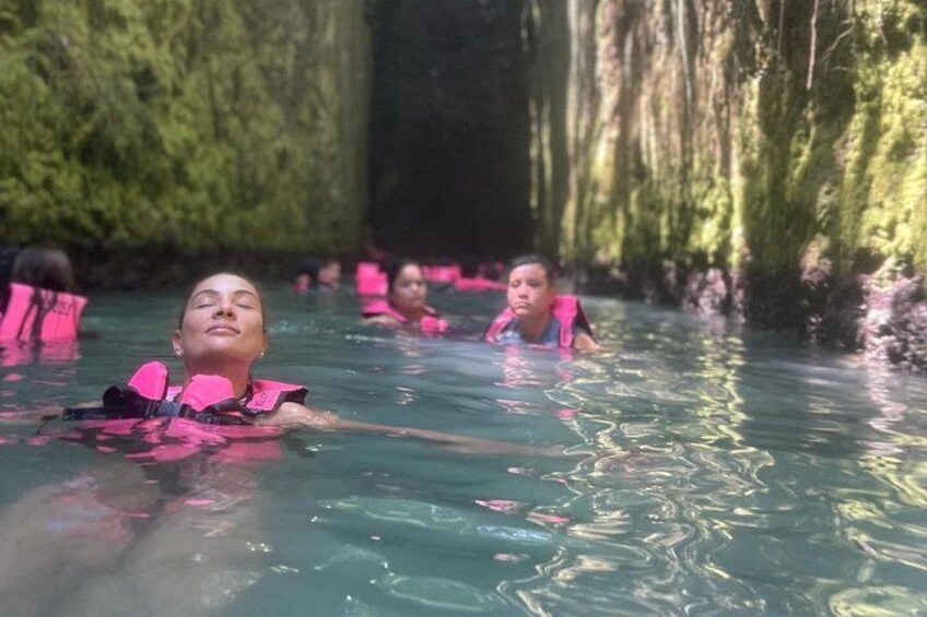 Personas en un manantial termal natural con paredes cubiertas de musgo. 3