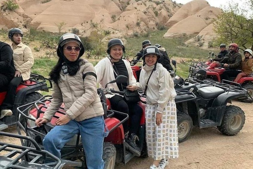 Un grupo de personas en cuatrimotos en un paisaje desértico con colinas rocosas al fondo. 5