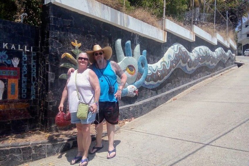 Two people standing in front of a dragon mural on a wall. 4