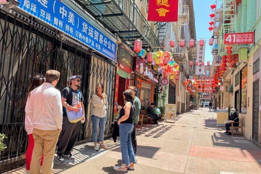 A narrow street lined with shops, red lanterns, and a sign for 41 Ross. 1