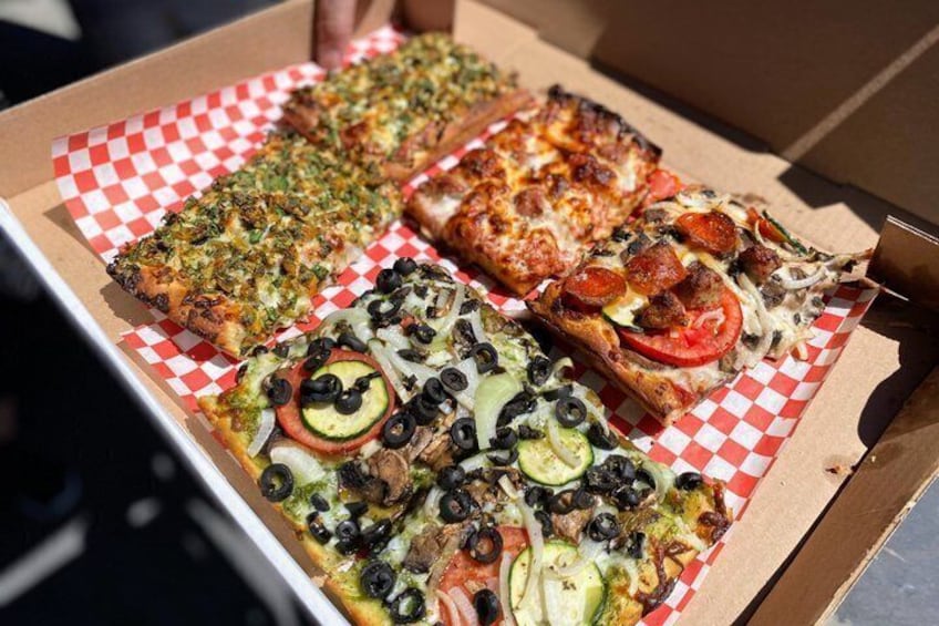 A box of four different pizzas with various toppings. 5