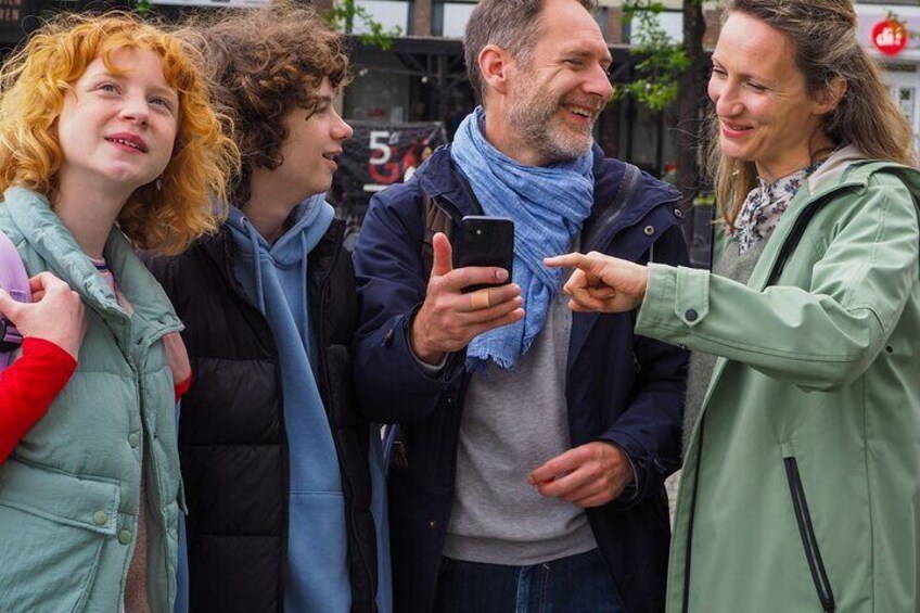 Cuatro personas al aire libre, una sosteniendo un teléfono inteligente. 1