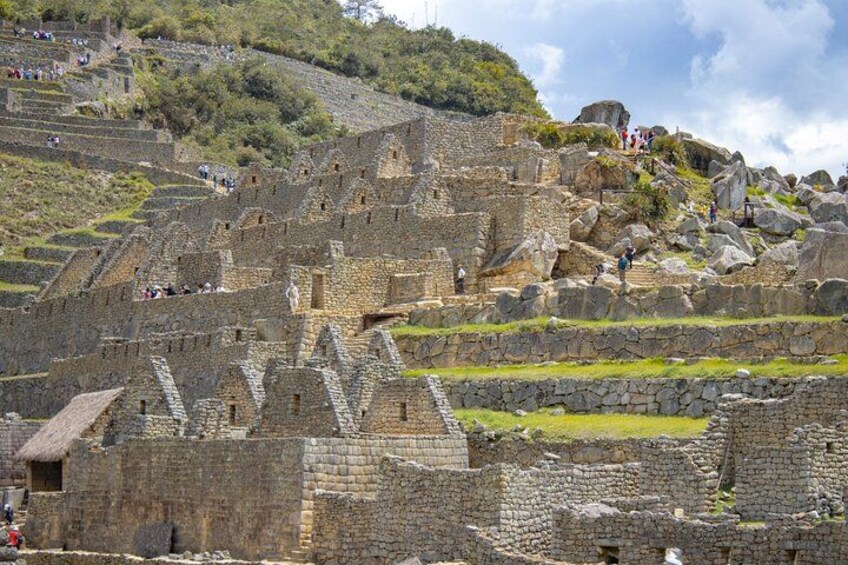 Ancient stone ruins with stepped terraces and visitors. 2