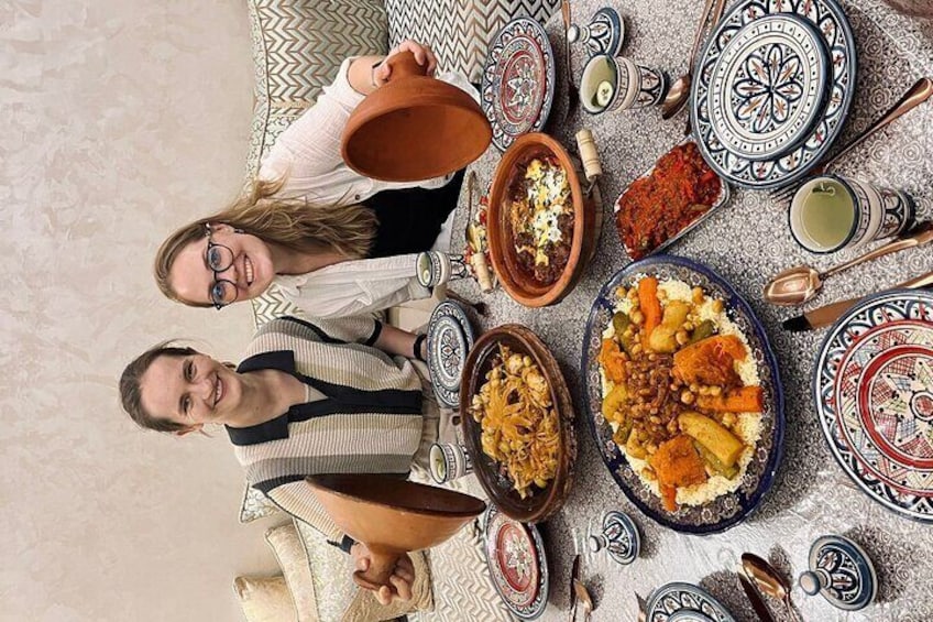 Ett bord med olika rätter, inklusive en stor tallrik med couscous, skålar med soppa och en tekanna. 2