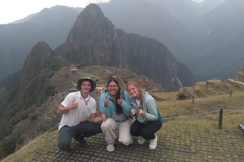 Trois personnes posent devant le Machu Picchu. 4