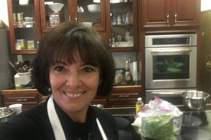 A person in a kitchen with wooden cabinets, a stainless steel oven, and various kitchen items. 3