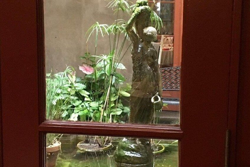 A window with a view of a garden, including a statue and various plants. 4