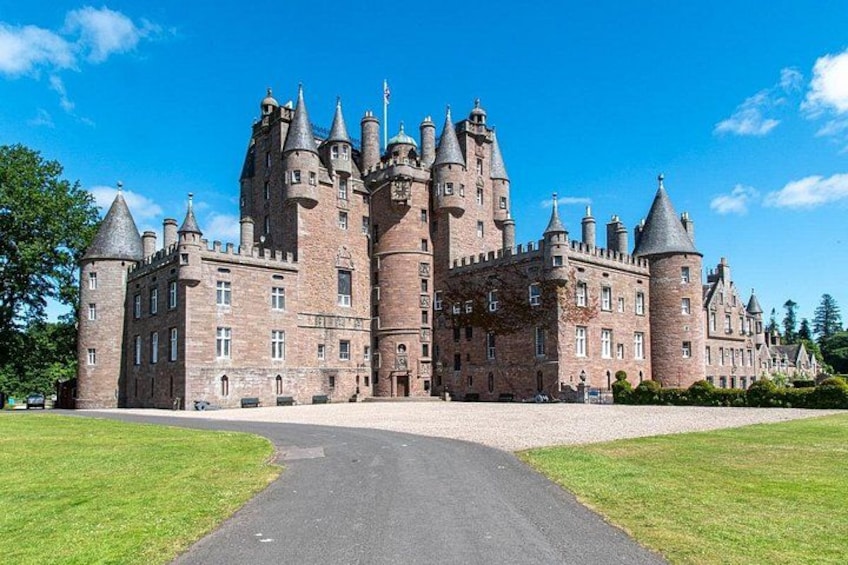 Un vaste château historique doté de nombreuses tours et d’une pelouse bien entretenue. 2