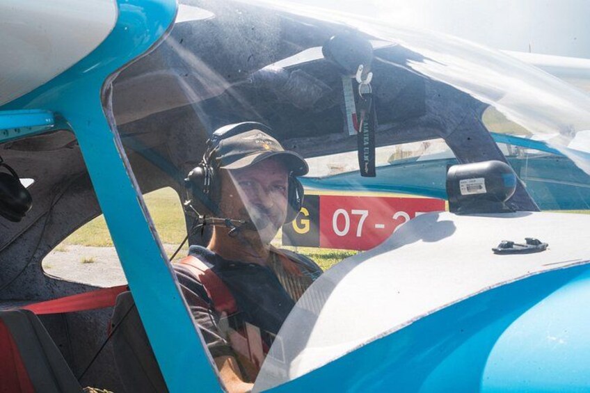 A person in a cockpit of a small aircraft with a visible registration number. 5