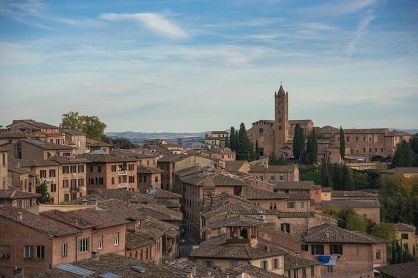 A historic town with traditional buildings, a prominent church, and a tower. 2