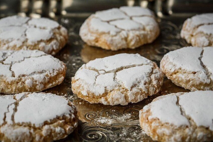 Round cookies with powdered sugar on a decorative tray. 3