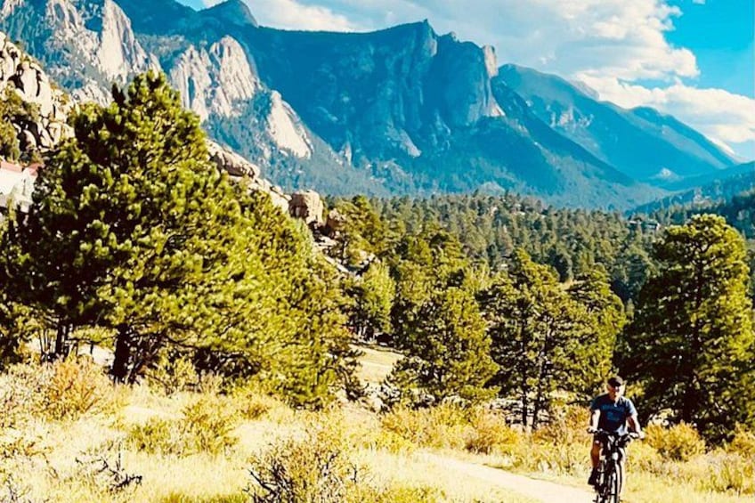 A mountain landscape with a cyclist on a trail. 1