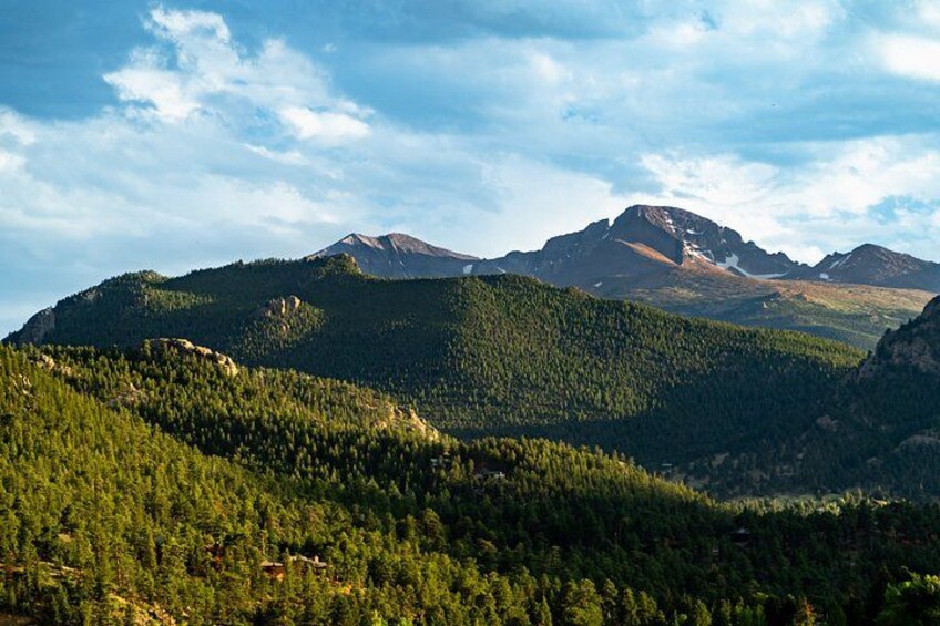 A mountainous landscape with dense forests and a prominent peak. 2