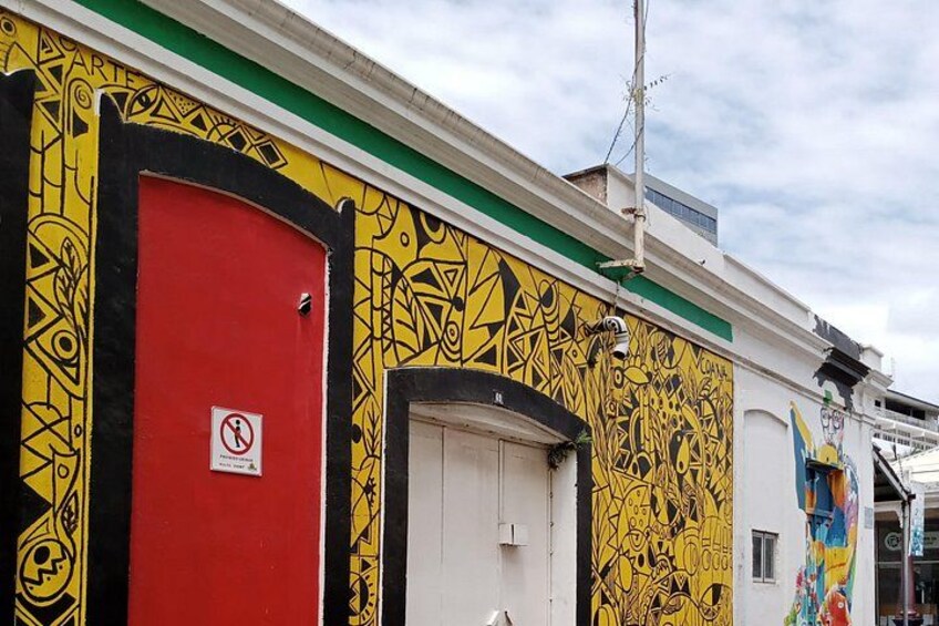 A building with a red door and graffiti art. 4