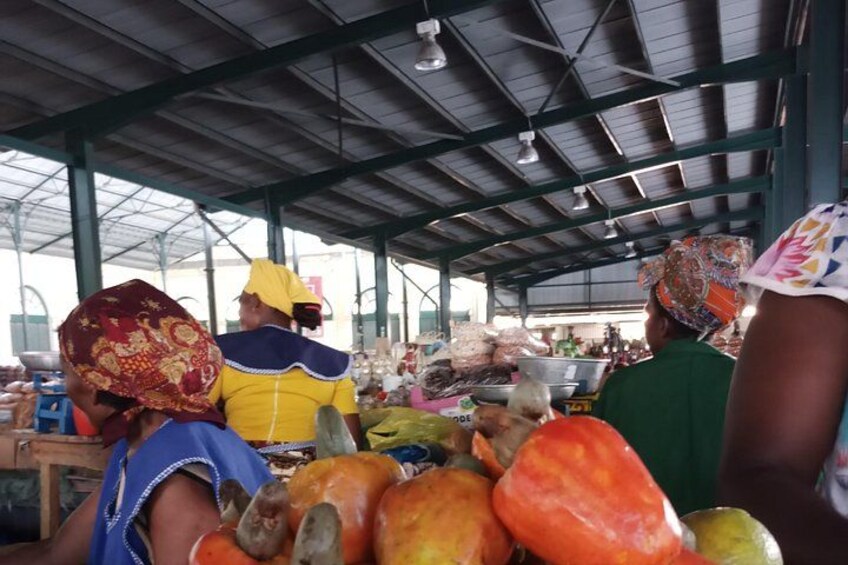 A covered market with people and produce. 5