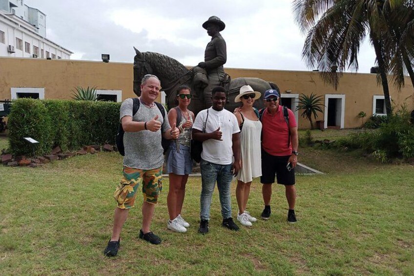 A group of people standing in front of a statue. 3