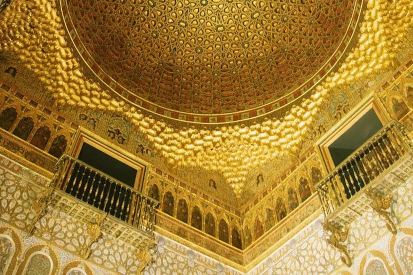 Un interior ornamentado con intrincados patrones dorados, un techo abovedado y detalladas decoraciones murales. 5