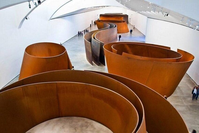 Un espace architectural moderne caractérisé par de grandes structures métalliques aux lignes courbes. 2