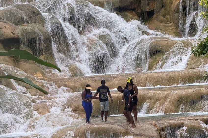 A waterfall with people standing on rocks. 3