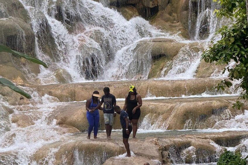 A waterfall with people standing on rocks. 5