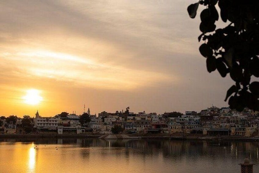 A sunset over a cityscape with buildings along a waterfront. 1