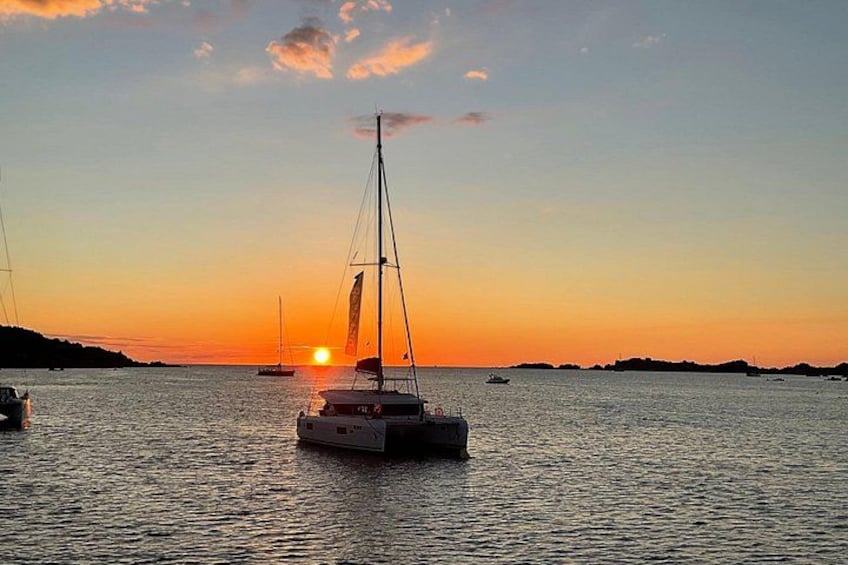 Een zonsondergang boven een rustige zee met zeilboten. 3