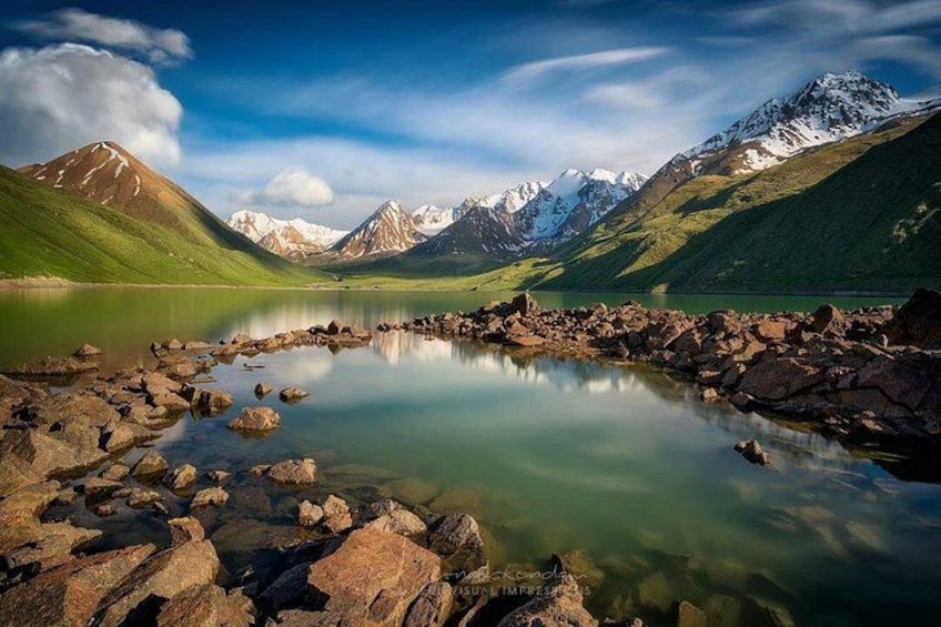 Un lago de montaña con aguas cristalinas, rodeado de costas rocosas y picos nevados. 1