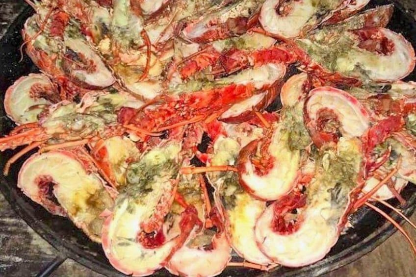 A platter of cooked lobsters with their shells partially removed, revealing the meat inside. 4