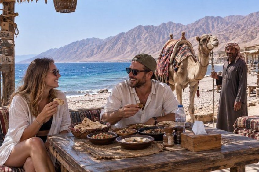 A beachside dining scene with a camel in the background. 2