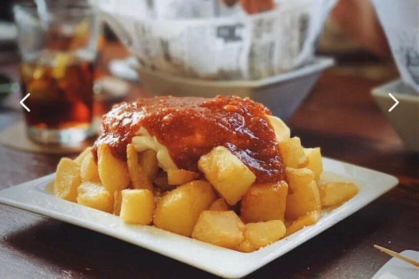 En tallrik med pommes frites, överdragen med ketchup. 2