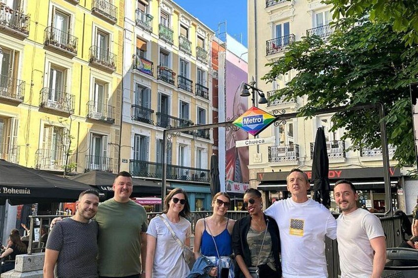 A group of people standing in front of a building with a Metro sign. 3