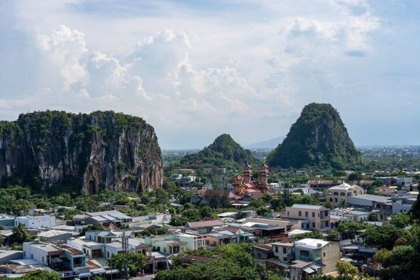 A town with buildings, a temple, and two prominent limestone cliffs. 4