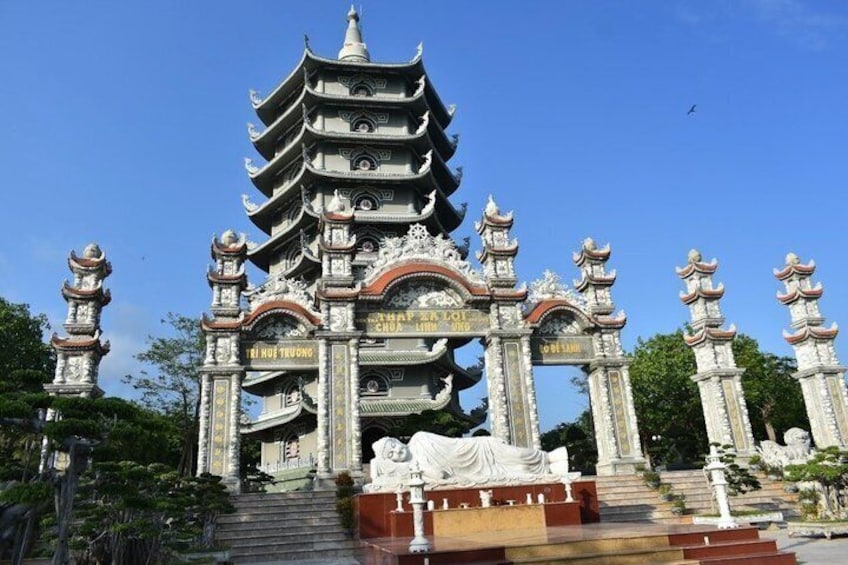A multi-tiered pagoda with ornate decorations and inscriptions, surrounded by statues and steps leading up to it. 5