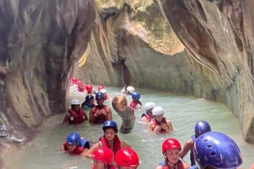 Mensen in het water, met helmen, in een grotachtige omgeving. 2