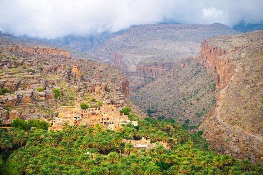 A mountainous landscape with a village nestled among lush greenery and rocky terrain. 3