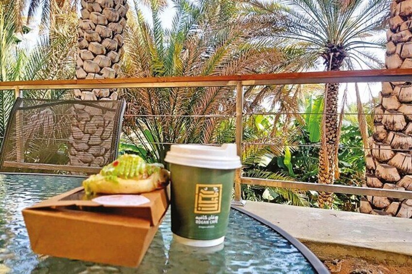 A glass table with a cup of coffee, a wrapped sandwich, and a box. 5