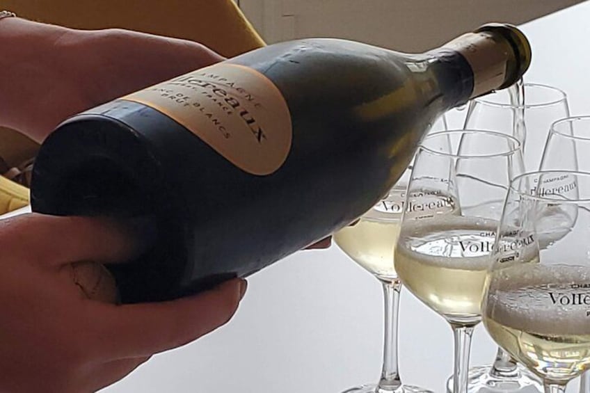 Eine Person schenkt Sekt in Gläser ein. 5