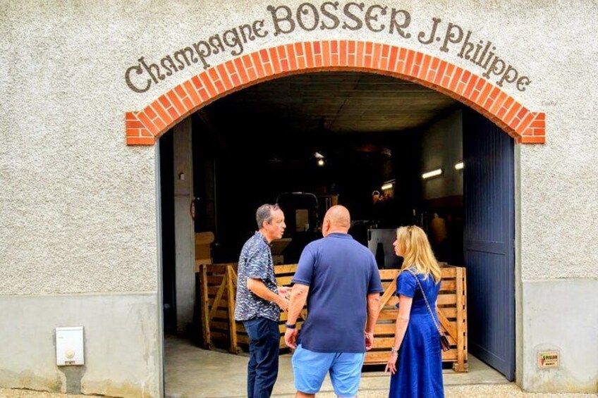 Ein Gebäude mit einem Schild, auf dem 'Champagne BOSSE R. Philippe' steht, und einer Holzkonstruktion im Inneren. 3
