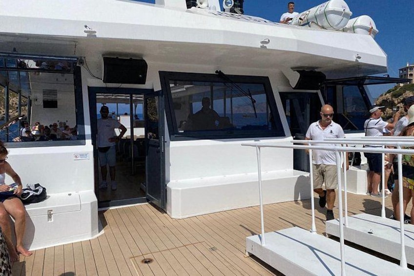 Un barco blanco con cubierta, personas a bordo y cielo despejado. 4