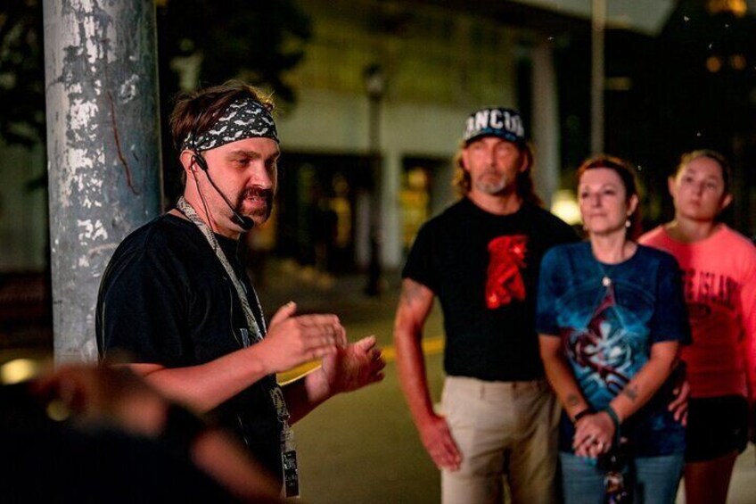 A group of people standing outdoors at night. 1