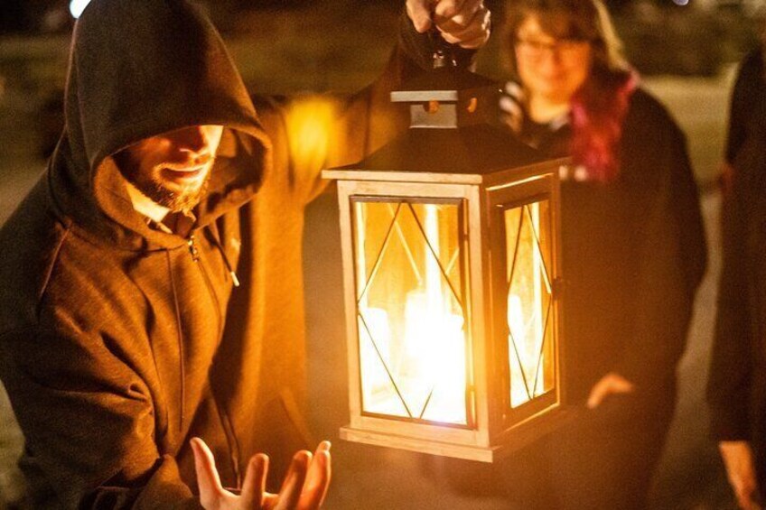 A person holding a lit lantern. 5