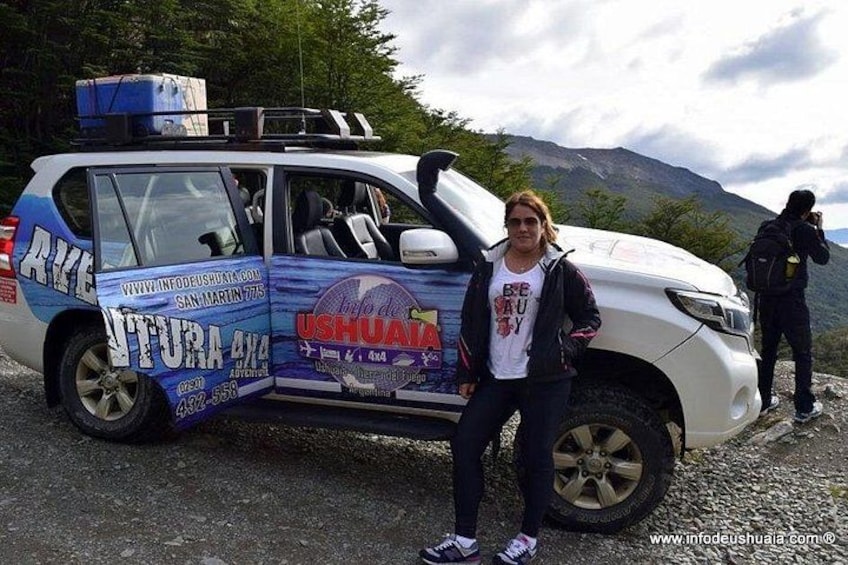 Un veicolo con la scritta 'UTURA 4x4' e 'USHUATA', parcheggiato su un fondo ghiaioso con montagne sullo sfondo. 3