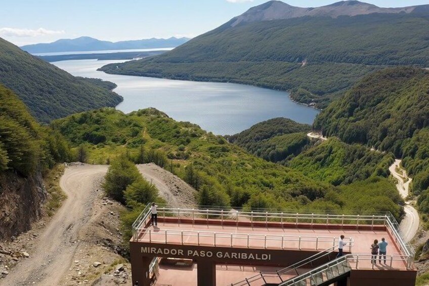 Un belvédère offrant une vue panoramique, avec un panneau indiquant « MIRADOR PASO GARIBALDI », surplombant un lac et des collines boisées. 4