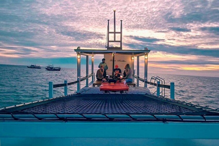 A boat with a covered seating area and people sitting at a table. 5